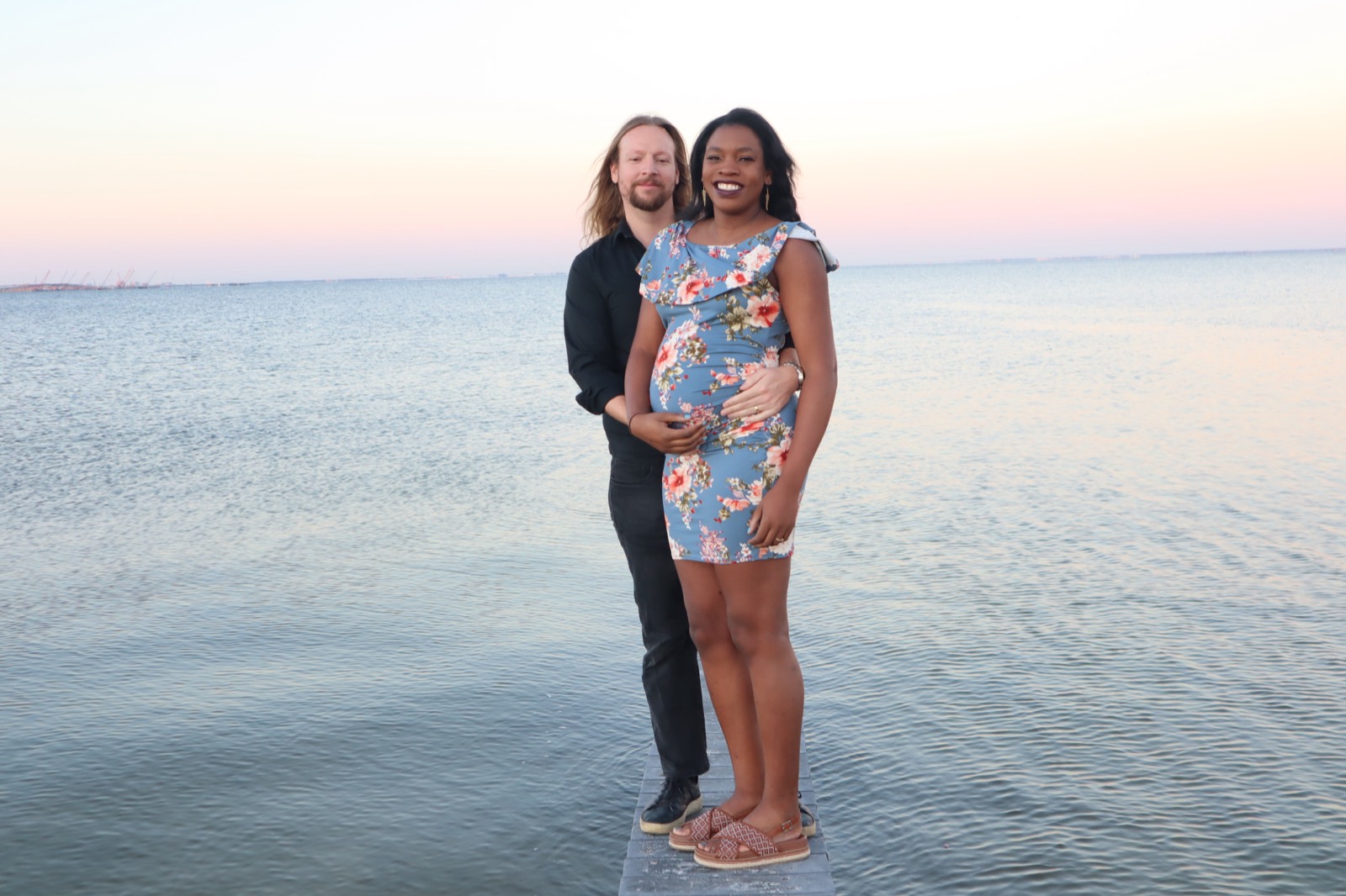 Tampa maternity photo session of an expecting couple on a dock at sunset